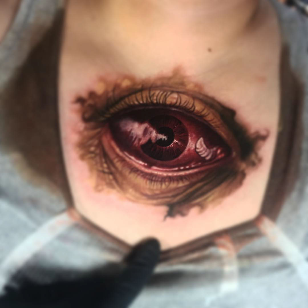 lower neck red eye tattoo