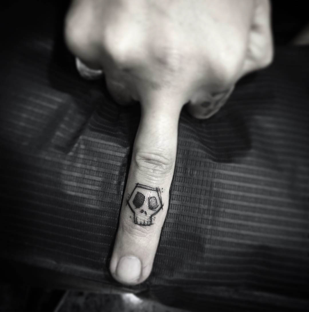 sketchy skull tattoo on finger